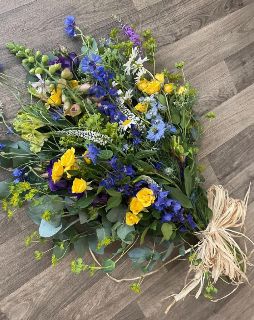 Yellow & Blue natural tied sheaf. A mix of cottage garden type florals with a raffia bow. All biodegradable - £65.00